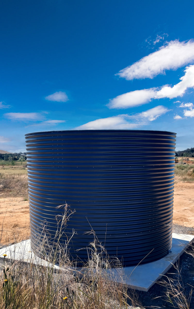 a woodland or slate grey water tank in a dusty field