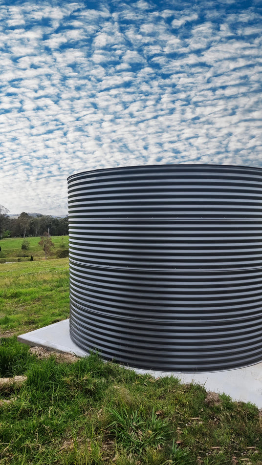 a large ccwt water tank on a concrete pad out in the paddock