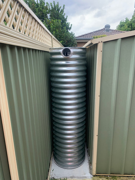 skinny slim water tank in behind a shed