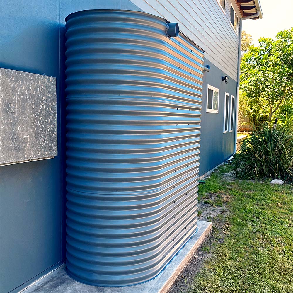 A slimline steel water tank beside an Australian home