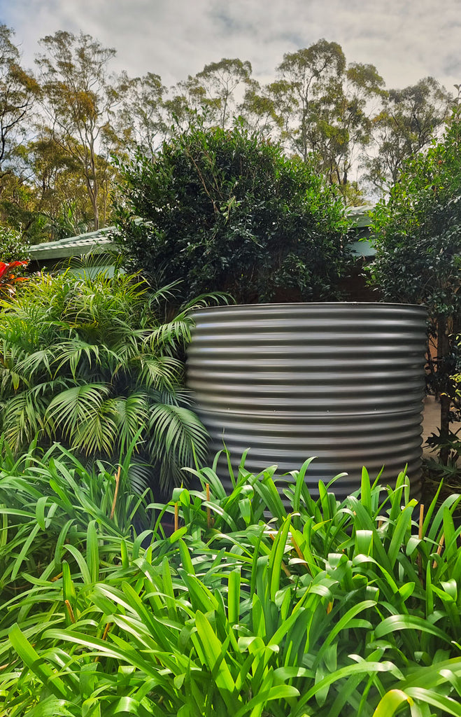 woodland grey water tank surrounded by a bunch of plants